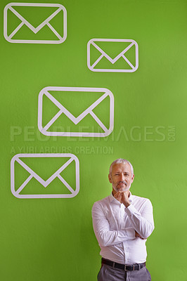 Buy stock photo Portrait of a mature businessman standing against a green background filled with message symbols