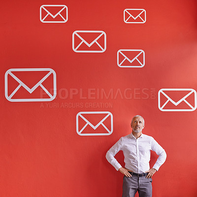 Buy stock photo Shot of a mature businessman standing against a red background filled with message symbols