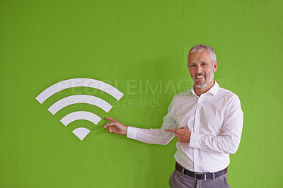 Buy stock photo Businessman, wall and symbol for wireless connection with portrait, smile and choice by green background. Mature person, happy and presentation with sign, icon and review at company for fast internet
