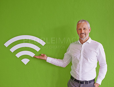 Buy stock photo Businessman, wall and sign for wireless connection with portrait, smile and choice by green background. Mature person, happy and presentation with symbol, icon and review at company for fast internet