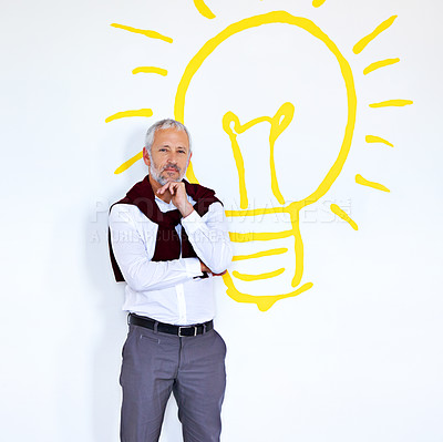 Buy stock photo Portrait of a mature businessman standing against a white background with a lightbulb on it