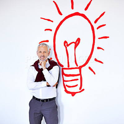 Buy stock photo Portrait of a mature businessman standing against a white background with a lightbulb on it