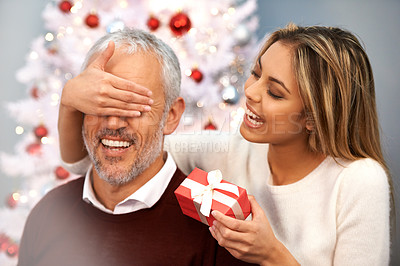 Buy stock photo Shot of a young woman surprising her father with a Christmas present