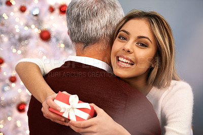 Buy stock photo Shot of a beautiful young woman embracing her father after receiving a Christmas present from him