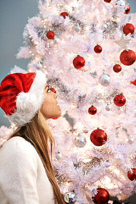 Buy stock photo Woman, hat and thinking by christmas tree in home for holiday celebration, festive season and tradition. Person, accessory or watching decoration for December vacation, daydreaming and smile in house