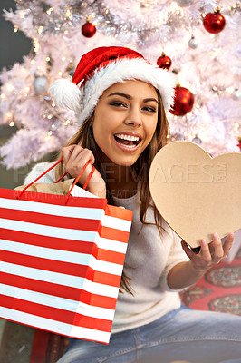 Buy stock photo Portrait of a beautiful young woman looking excited while sitting with her Christmas presents