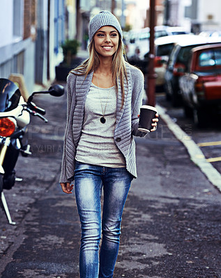 Buy stock photo Shot of a beautiful young woman walking with a takeaway coffee in the city