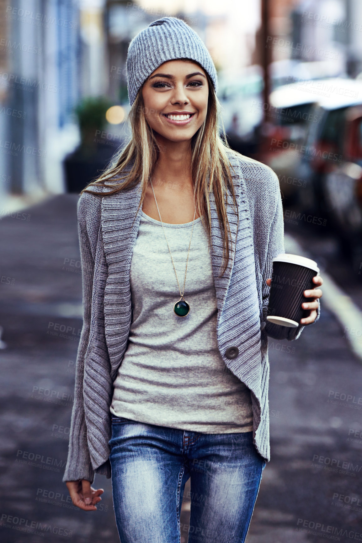Buy stock photo Portrait of a beautiful young woman walking with a takeaway coffee in the city