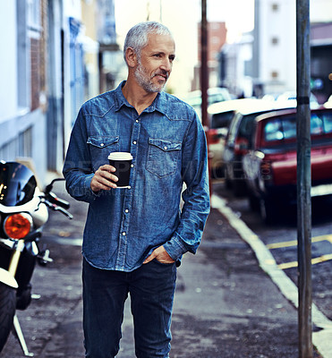 Buy stock photo Shot of a handsome mature man walking with a takeaway coffee in the city