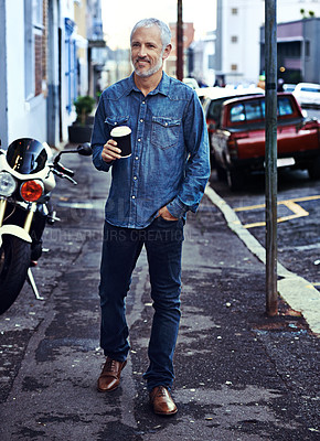 Buy stock photo Shot of a handsome mature man walking with a takeaway coffee in the city