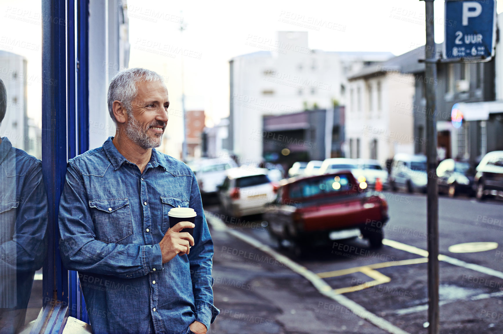 Buy stock photo Shot of a handsome mature man drinking takeaway coffee while out in the city
