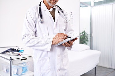 Buy stock photo Cropped shot of a male doctor using a digital tablet at a hospital