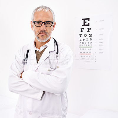 Buy stock photo Portrait of a mature male optometrist standing in his office with an eye chart in the background