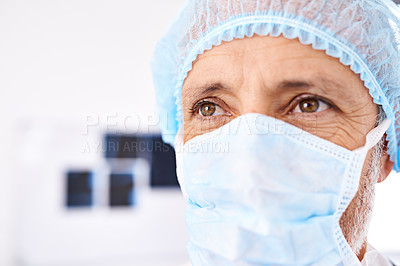 Buy stock photo Shot of a mature male surgeoun wearing a surgical mask and cap