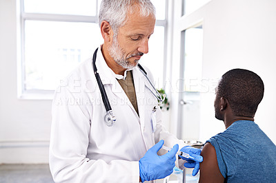 Buy stock photo Shot of a mature male doctor giving his patient an injection
