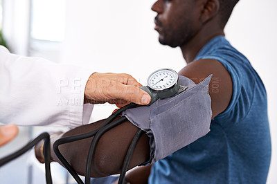 Buy stock photo Cropped shot of a doctor taking a male patient's blood pressure