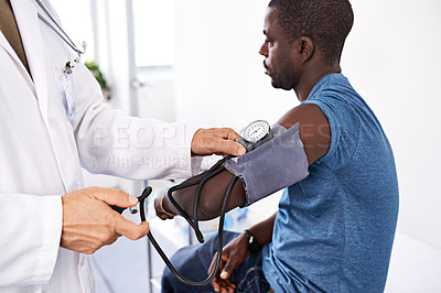 Buy stock photo Cropped shot of a doctor taking a male patient's blood pressure