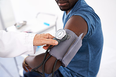 Buy stock photo Cropped shot of a doctor measuring a patient's blood pressure