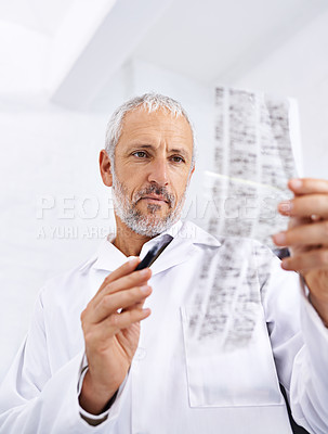 Buy stock photo Shot of a male scientist analyzing the results of a DNA test