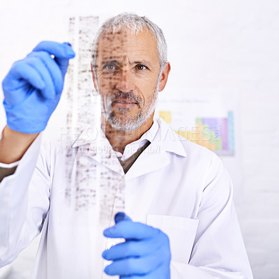 Buy stock photo Shot of a male scientist examining the results of a DNA test