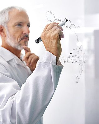 Buy stock photo Shot of a mature male scientist drawing a molecular structure on a glass surface