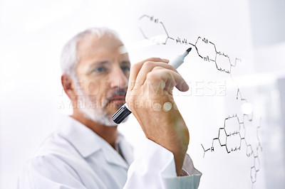 Buy stock photo Shot of a mature male scientist drawing chemical bonds on a glass surface