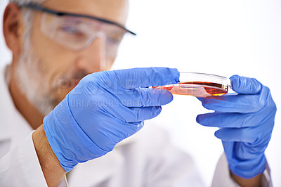 Buy stock photo Cropped shot of a male scientist examining the contents of a petri dish