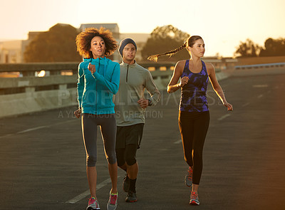 Buy stock photo Road, city and friends running at sunset for fitness, training club and commitment to healthy body. Evening, exercise and people on street together for urban workout, outdoor challenge or wellness