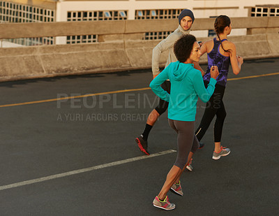 Buy stock photo Workout, city and people running on bridge together for sports training, commitment and body health. Evening, exercise and group of friends on road for urban fitness with outdoor challenge on street