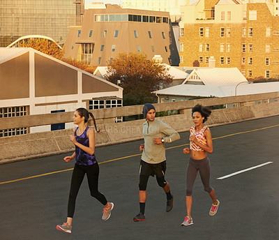 Buy stock photo Urban, training and people on street running together for sports workout, commitment and body health. Evening, city and group of friends on road for fitness, exercise or outdoor wellness challenge