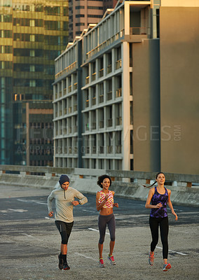 Buy stock photo Urban, buildings and people running on road together for fitness, training or commitment to healthy body. Evening, exercise and group of friends on street for city workout with outdoor challenge