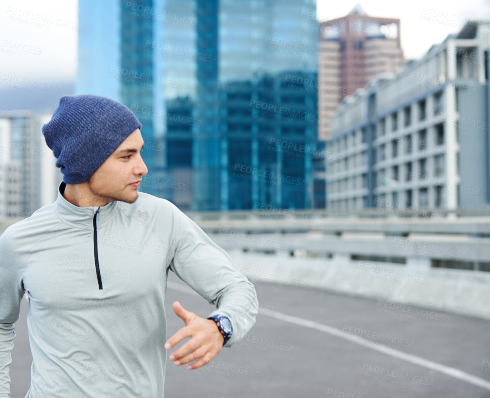 Buy stock photo Cropped shot of a young man jogging through empty city streets