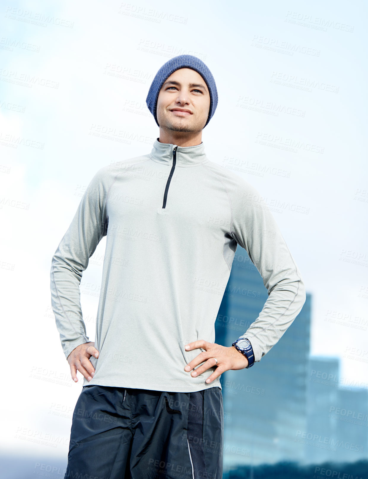 Buy stock photo Shot of a young jogger taking in his urban surroundings 