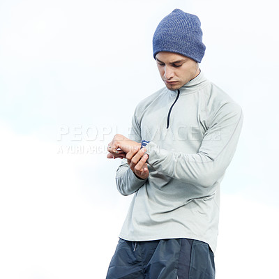 Buy stock photo Shot of a young jogger checking the time while out for a run in the city