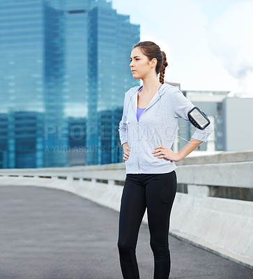 Buy stock photo Thinking, earphones and woman in city for workout, running or fitness on bridge with music. Sports, arm band and female athlete with audio tech for listening to podcast on cardio training in town.