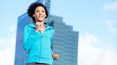 Buy stock photo Shot of a young woman jogging through empty city streets