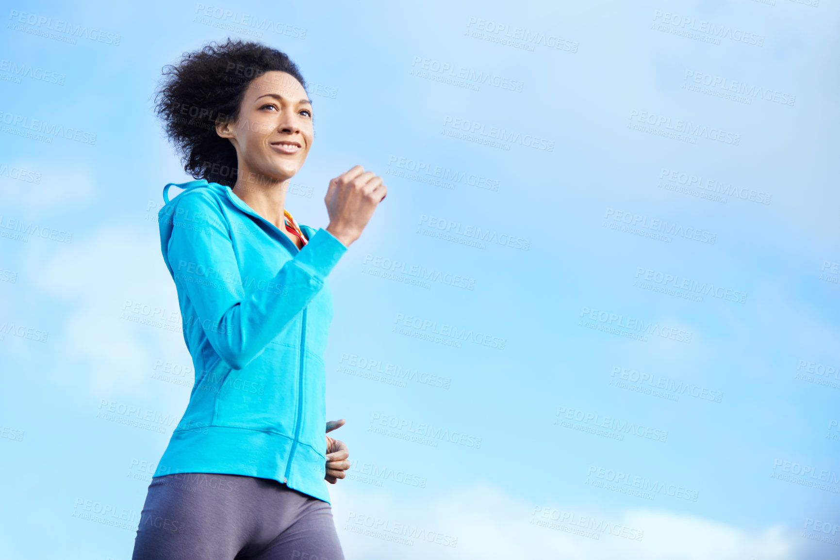Buy stock photo Shot of a young woman jogging on a clear day