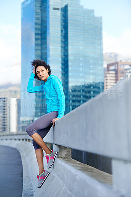 Buy stock photo Portrait of a young female jogger leaning against a road railing in the city