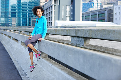 Buy stock photo Portrait of a young female jogger leaning against a road railing in the city