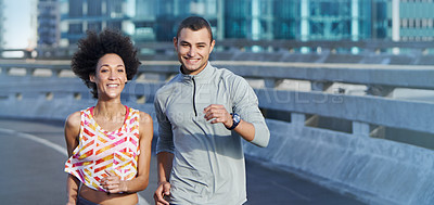 Buy stock photo Portrait of two friends jogging together through the city streets
