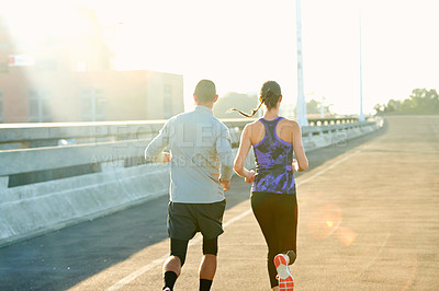 Buy stock photo Back, couple and running on road for fitness with training, support and care in California. People, exercise and workout with jogging for health or wellness and wellbeing in sportswear in lens flare