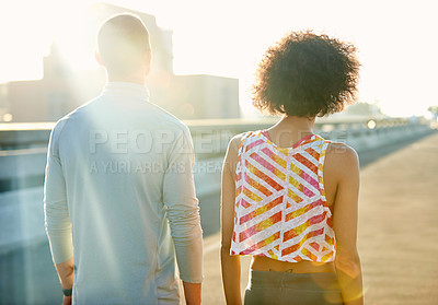 Buy stock photo Rearview shot of two friends taking in the sunrise during a jog through the city