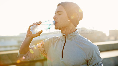 Buy stock photo Man, fitness and drinking with water bottle in city for hydration after workout, training or outdoor exercise. Active, male person or thirsty runner with mineral liquid for natural sustainability