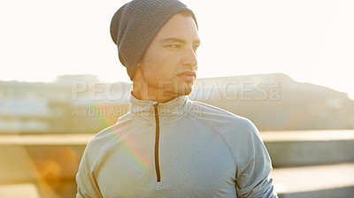 Buy stock photo Shot of a young male jogger taking in the view while on a run through the city streets