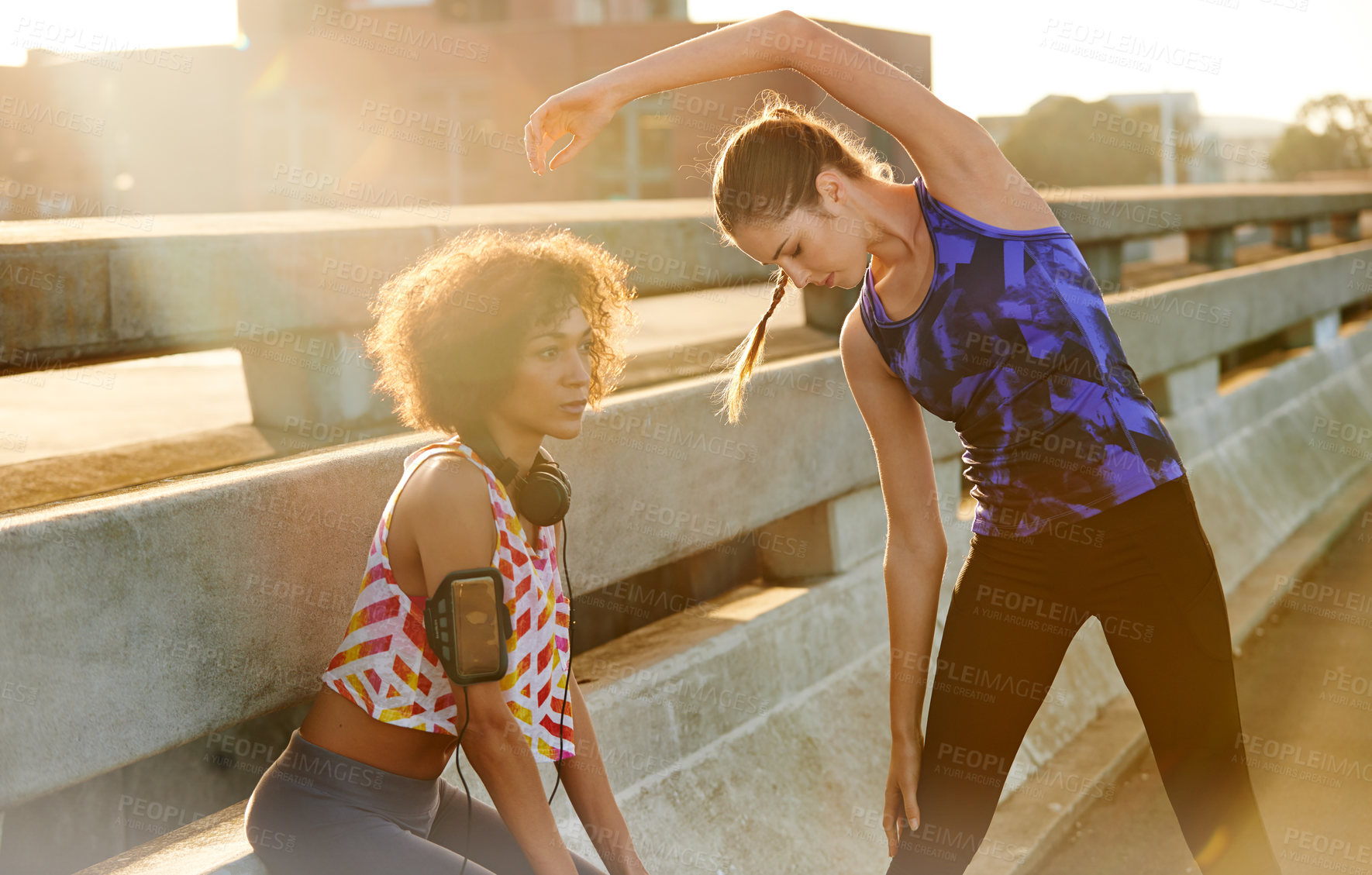 Buy stock photo Shot of two female joggers preparing for a jog in the city