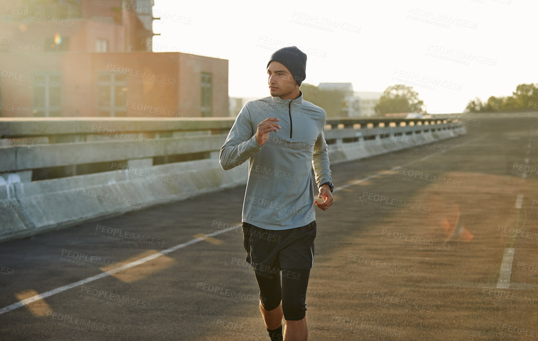 Buy stock photo Man, runner and sunrise in bridge, exercise and outdoor for fitness, training and health in morning. Person, city and direction on metro street at dawn for workout, progress and prepare for marathon