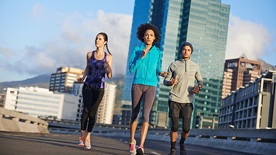 Buy stock photo Man, women and running together in city for fitness, training or commitment to healthy body. Morning, exercise and group of friends on road for urban workout, outdoor challenge or sports performance