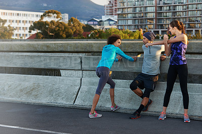 Buy stock photo Fitness, people and stretching with road in city for workout, training or outdoor exercise together. Young, group or runners in warm up for run, cardio or practice on street in health and wellness