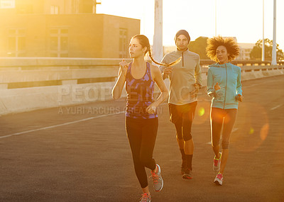 Buy stock photo Road, people and running in city at sunset for fitness, training and commitment to healthy body. Evening, exercise and friends on street for urban workout, outdoor challenge or sports performance