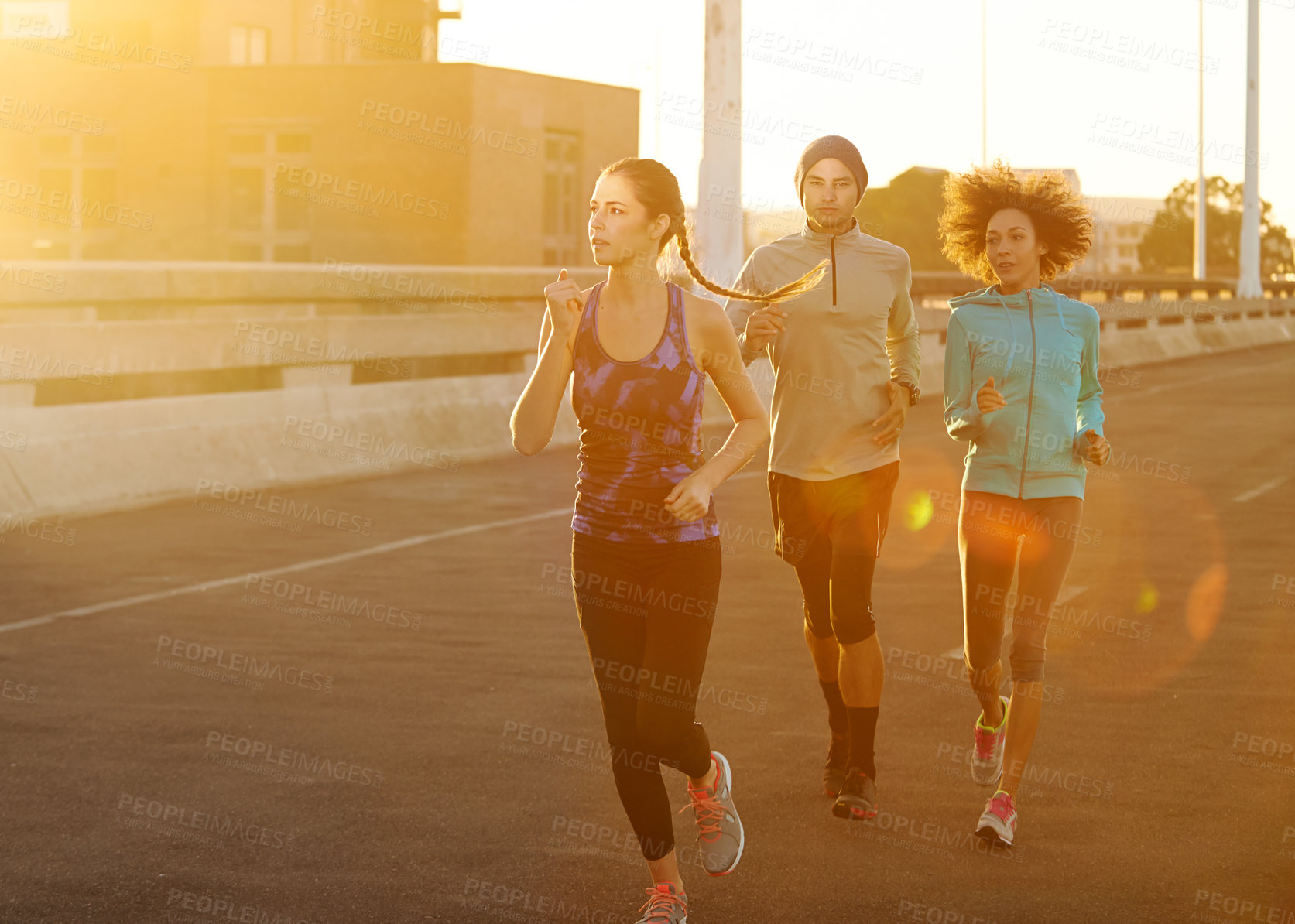 Buy stock photo Road, people and running in city at sunset for fitness, training and commitment to healthy body. Evening, exercise and friends on street for urban workout, outdoor challenge or sports performance